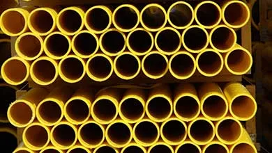 Symmetrical close-up of bright yellow pipes stacked in horizontal rows.