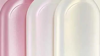 Three rounded bottles with smooth, curved surfaces stand side by side. Each bottle features a gradient from pink at the top to white at the bottom, highlighted by subtle light reflections.